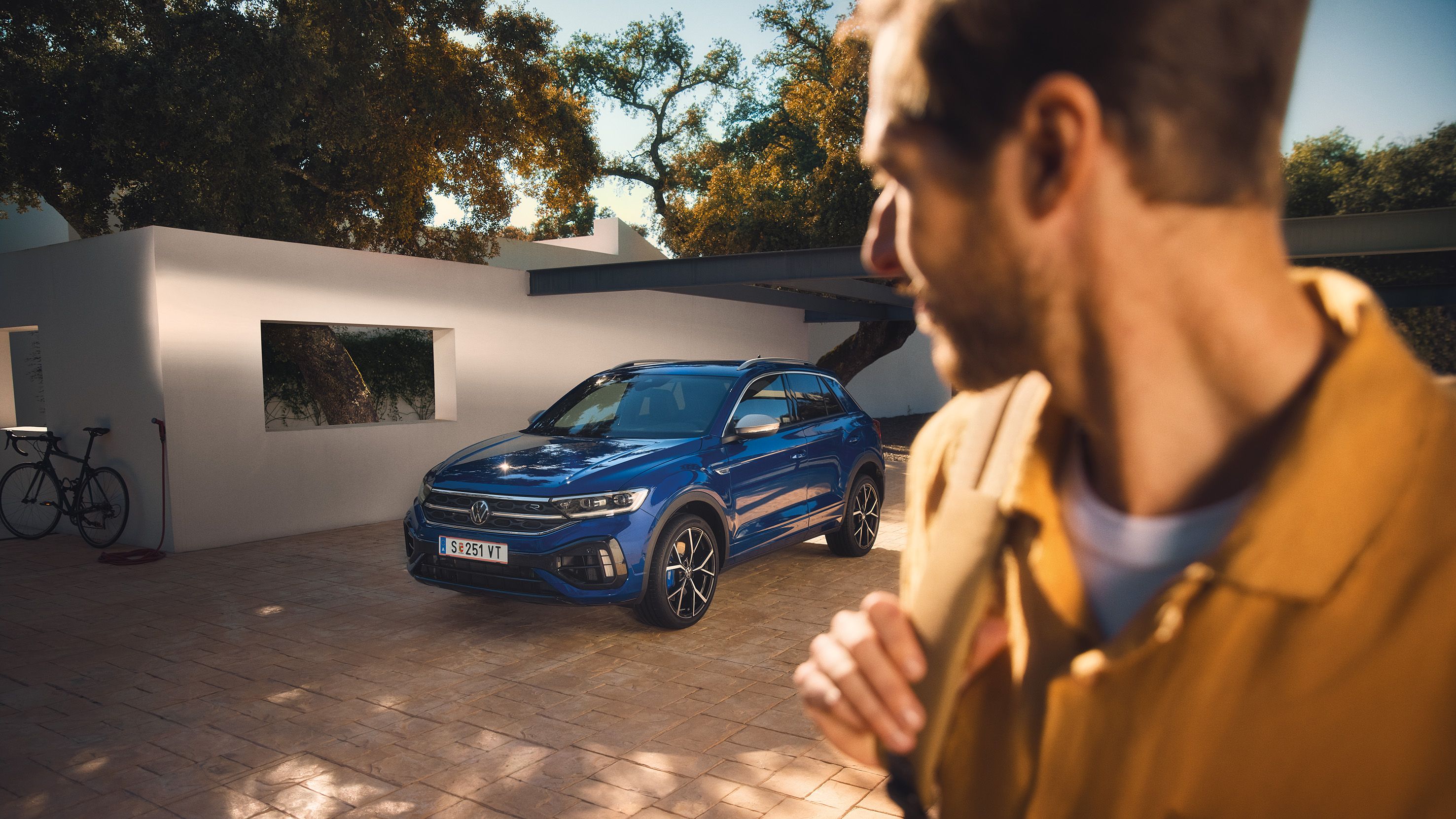 Mann blickt auf lapizblauen VW T-Roc R