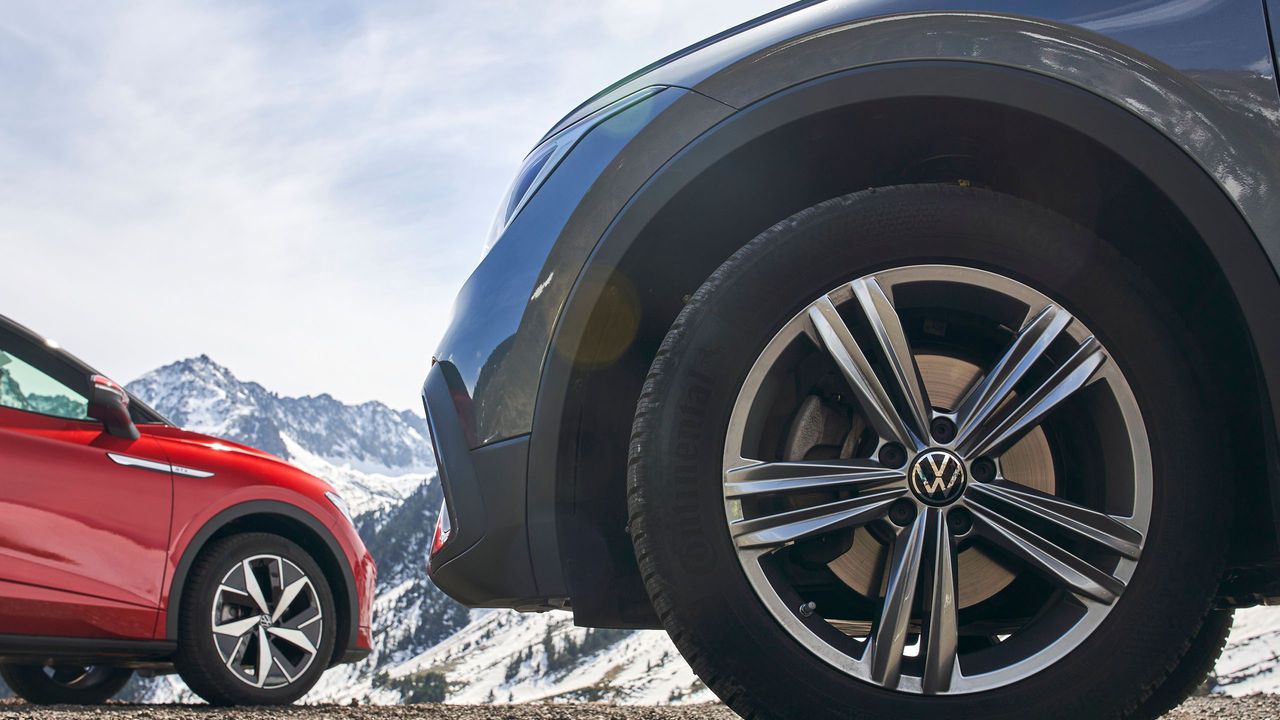 Nahaufnahme von Volkswagen Winterkompletträdern an einem blauen und an einem roten Volkswagen.