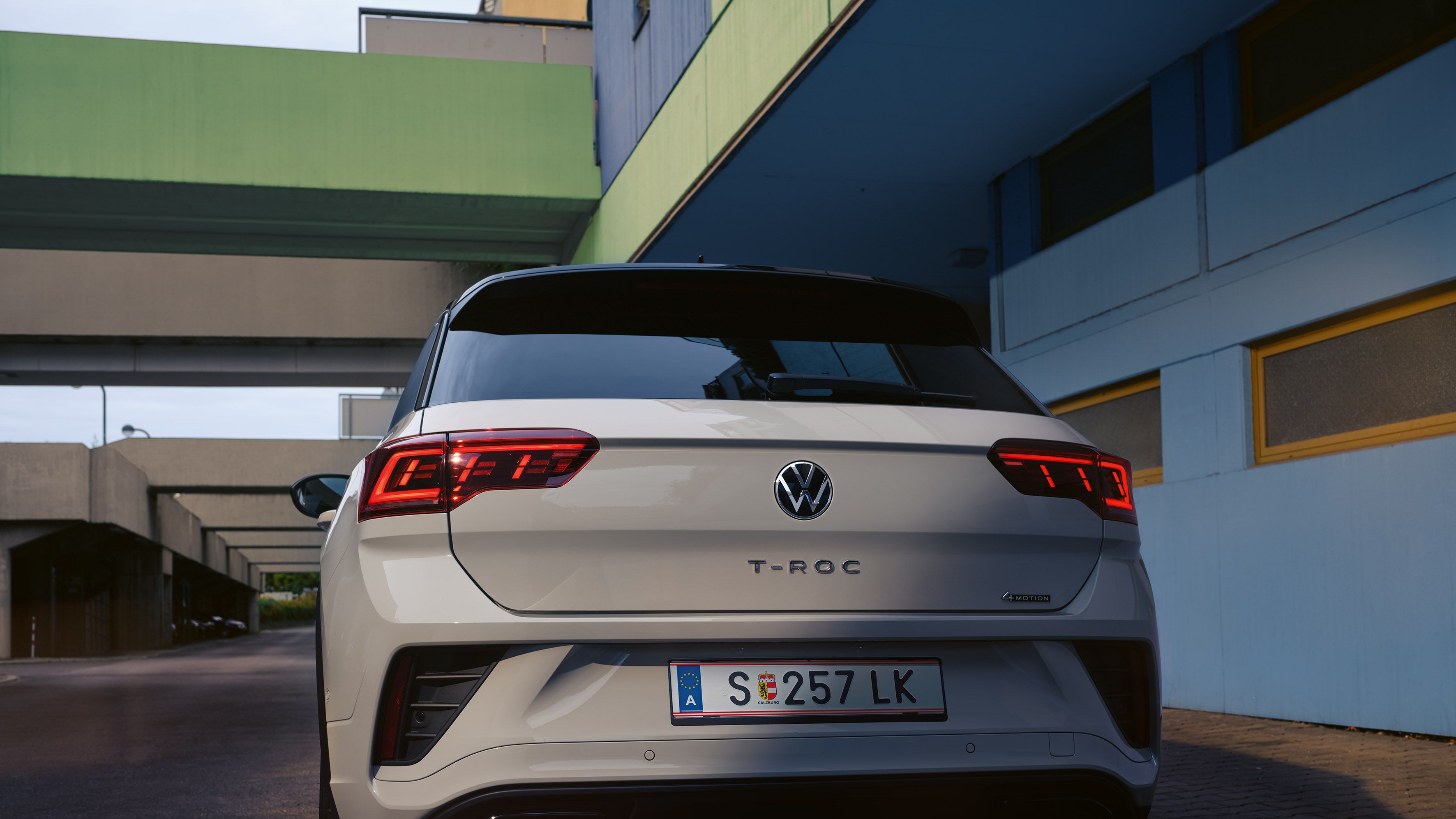 Heckansicht eines weißen VW T-Roc, parkend am Straßenrand
