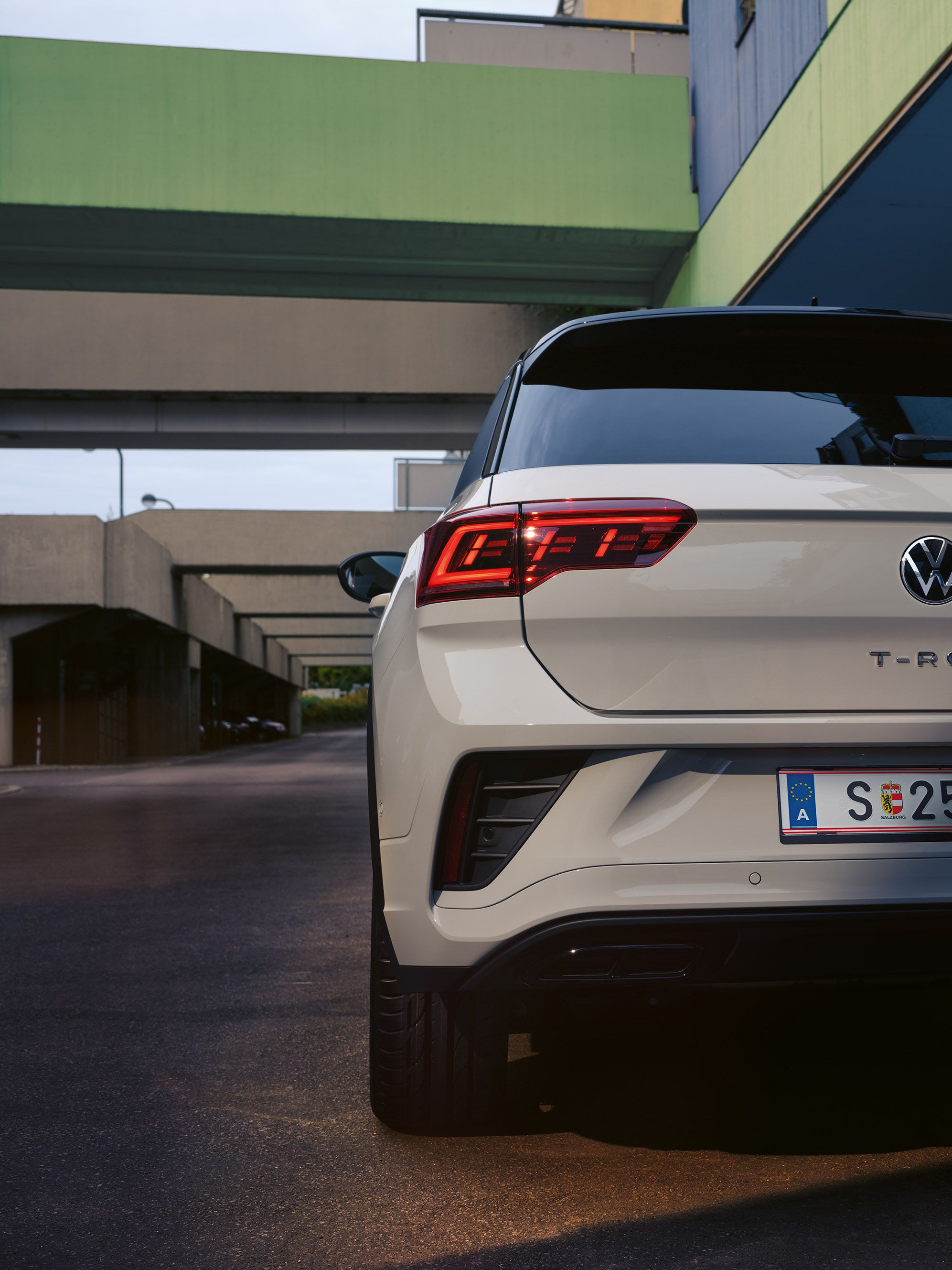 Heckansicht eines weißen VW T-Roc, parkend am Straßenrand