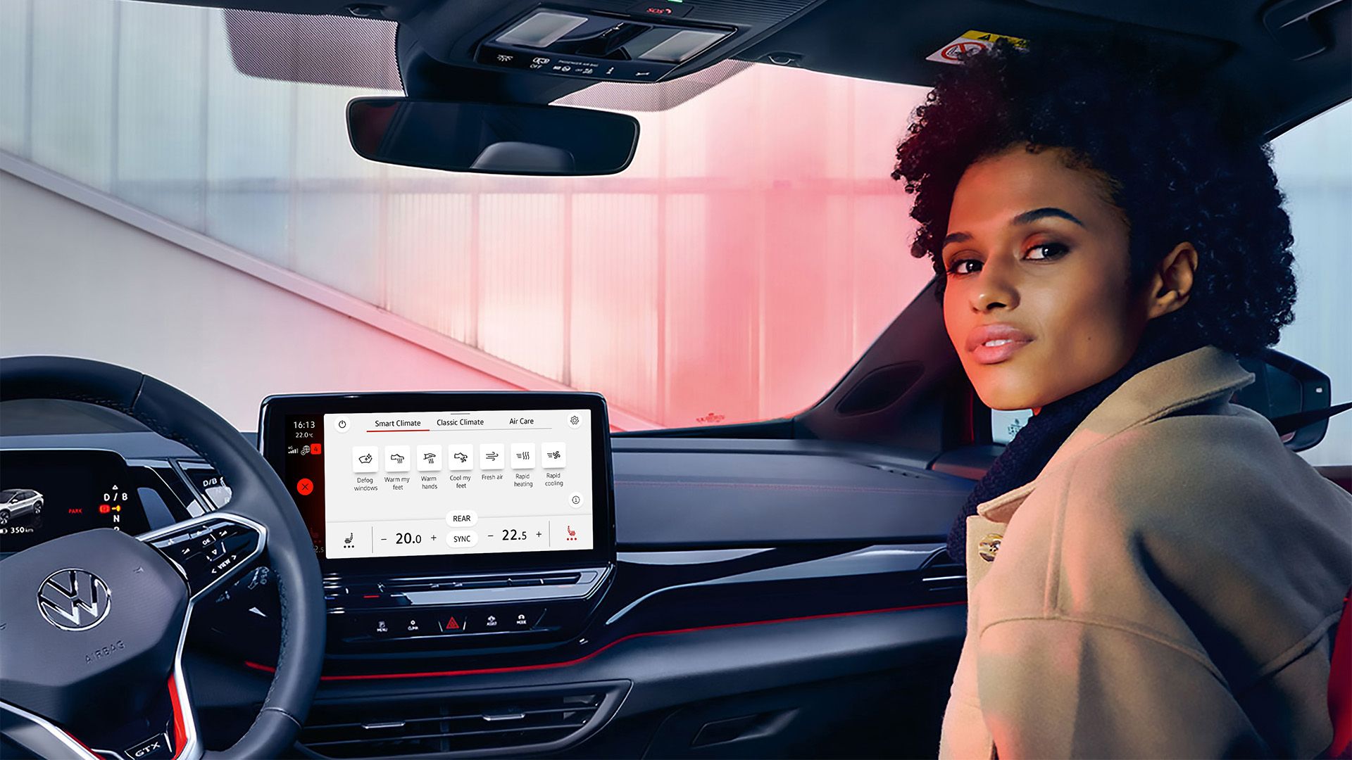 Junge Frau auf der Beifahrerseite des VW ID.4 GTX schaut den Betrachter an