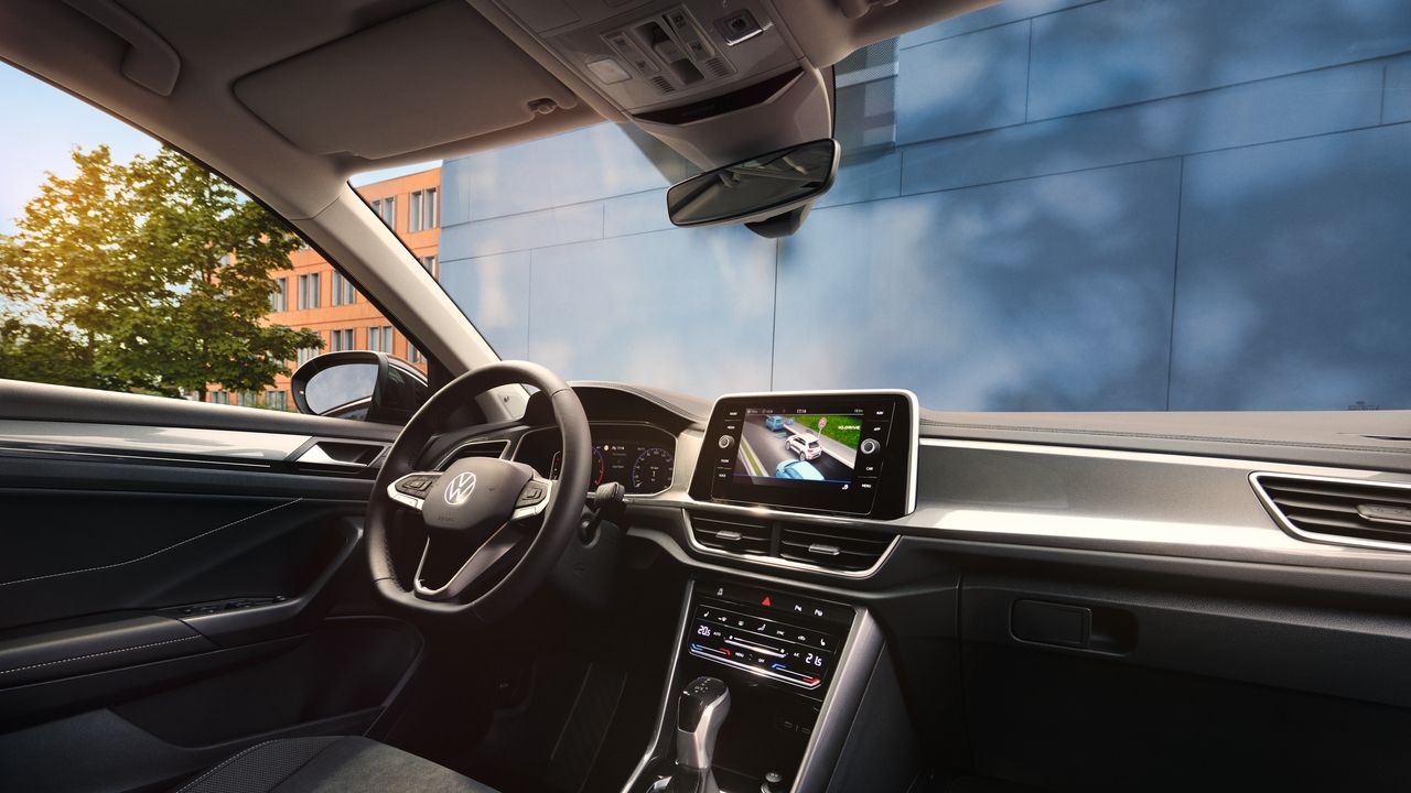 VW T-Roc Interieur, Sicht vom Beifahrersitz auf Fahrersitz und Cockpit mit Multifunktionslenkrad und Infotainment-System.